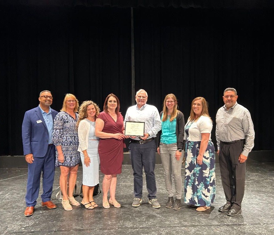 several coworkers together receiving an award